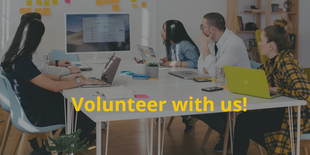 Volunteer with Us! Group of young adults with laptops open problem solving around a large white table. Text in yellow: Volunteer with us!